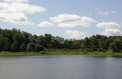 Scenic view of calm lake against cloudy sky