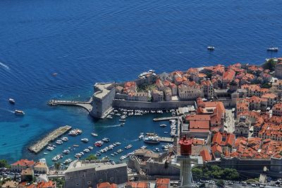 High angle view of townscape by sea against city