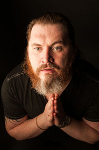 Portrait of man against black background