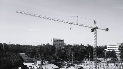 Cranes against sky in city