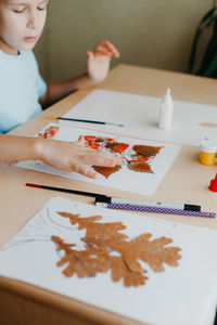 Portrait of boy drawing on table