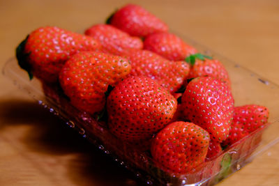 Close-up of strawberries in plastic container on table