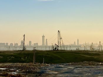 Bridge over river in city against clear sky