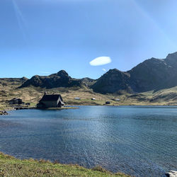 Scenic view of lake and mountains against blue sky