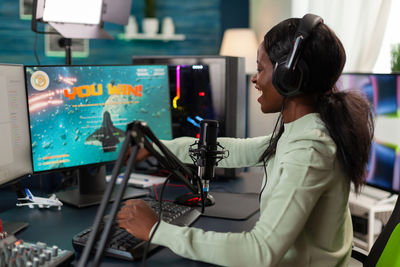 Excited gamer playing game on computer at home