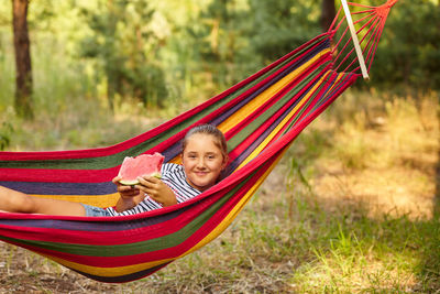 Rear view of woman sitting on hammock