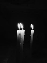 Close-up of illuminated candles in darkroom