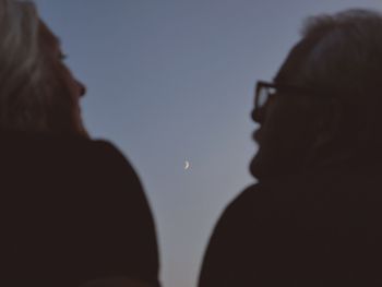 Close-up portrait of silhouette people against sky