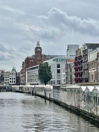 Bridge over river in city against sky