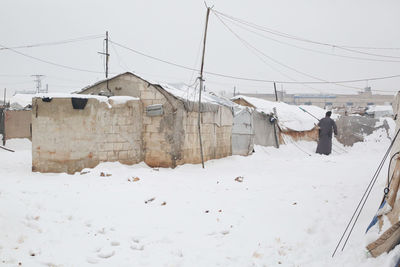 A refugee  clears his tent of snow that has devastated syrian refugee camps near the turkish border.