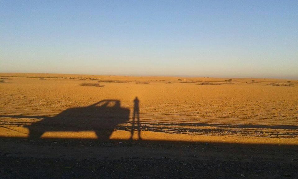 SHADOW OF MAN RIDING ON DESERT