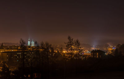 Illuminated buildings against sky at night