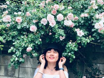 Portrait of smiling woman standing against plants