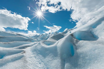 Aerial view of snowcapped mountain against sky on sunny day