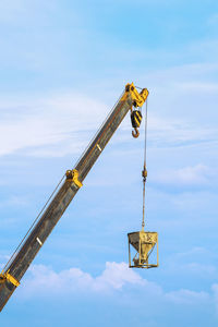 Low angle view of crane against sky