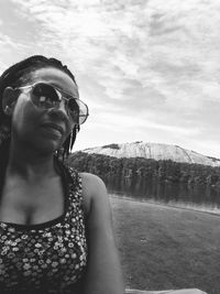 Portrait of young woman in sunglasses against sky