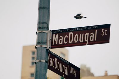 Low angle view of road sign against sky