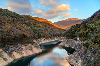 Scenic view of river amidst mountains against sky