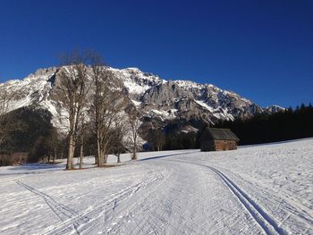 Scenic view of snow covered mountains against clear blue sky