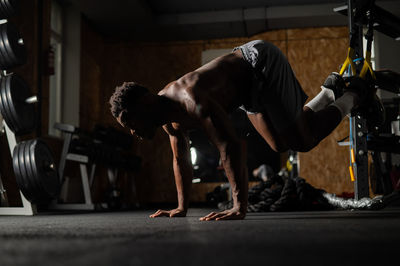 Low section of man with dog standing in gym