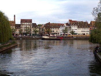 River by buildings against sky in city