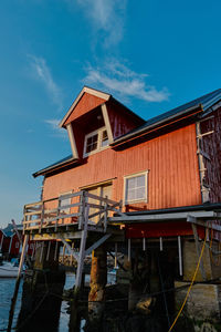 Low angle view of house by building against sky