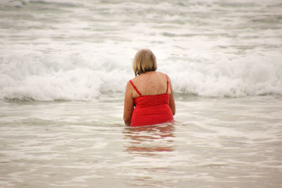 Rear view of woman standing in sea