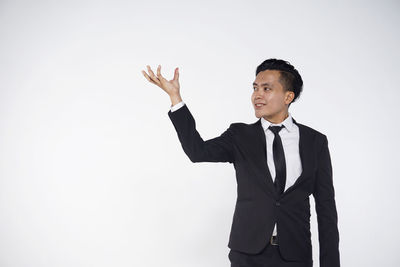 Young man standing against white background