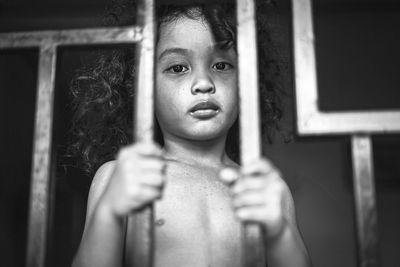Portrait of boy looking through window