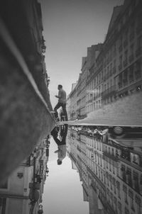 Man standing on bridge in city