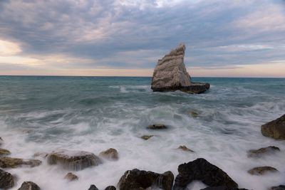 Scenic view of rocks in sea against sky