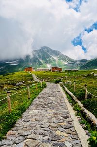 Road leading towards mountain against sky