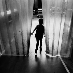 Rear view of man walking in corridor