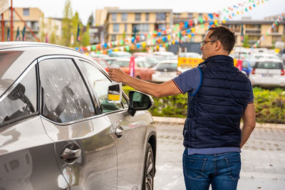 Rear view of man holding car