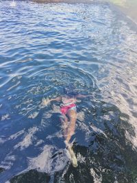 Low section of person swimming in water