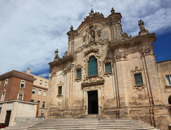 Low angle view of historic church against cloudy sky