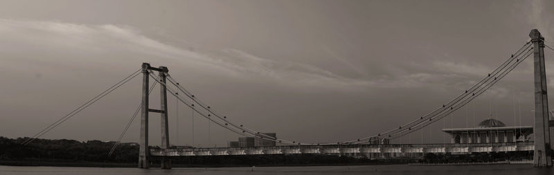 Low angle view of suspension bridge against sky