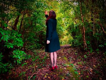 Rear view of woman standing in forest