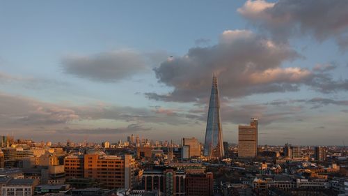 View of cityscape against cloudy sky