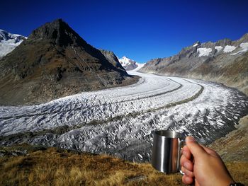 Midsection of snowcapped mountains against clear sky