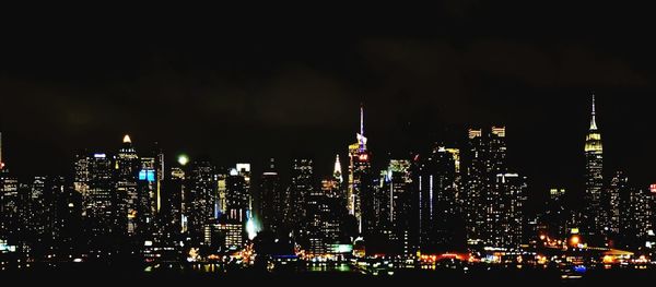 Illuminated cityscape against sky at night