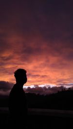 Silhouette man standing against sky during sunset