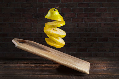 Close-up of bananas on table against brick wall