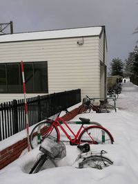 Bicycle on snow covered house by building