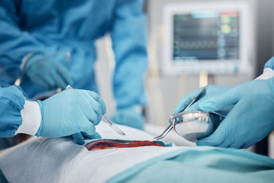 Midsection of doctor examining patient in hospital