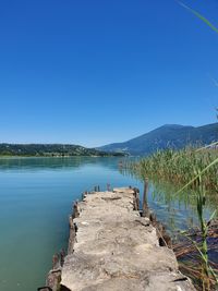 Scenic view of lake against clear blue sky
