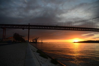 Bridge over calm sea at sunset