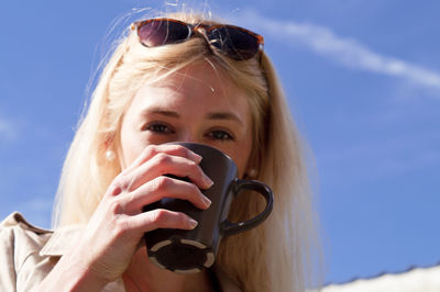Portrait of woman with sunglasses against sky