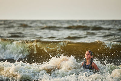 Rear view of woman swimming in sea