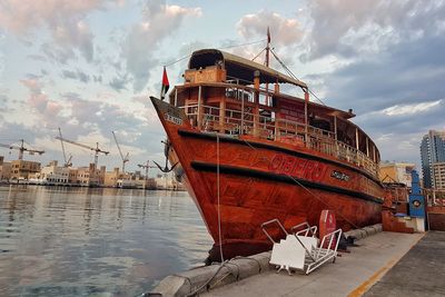 Ship moored at harbor against sky